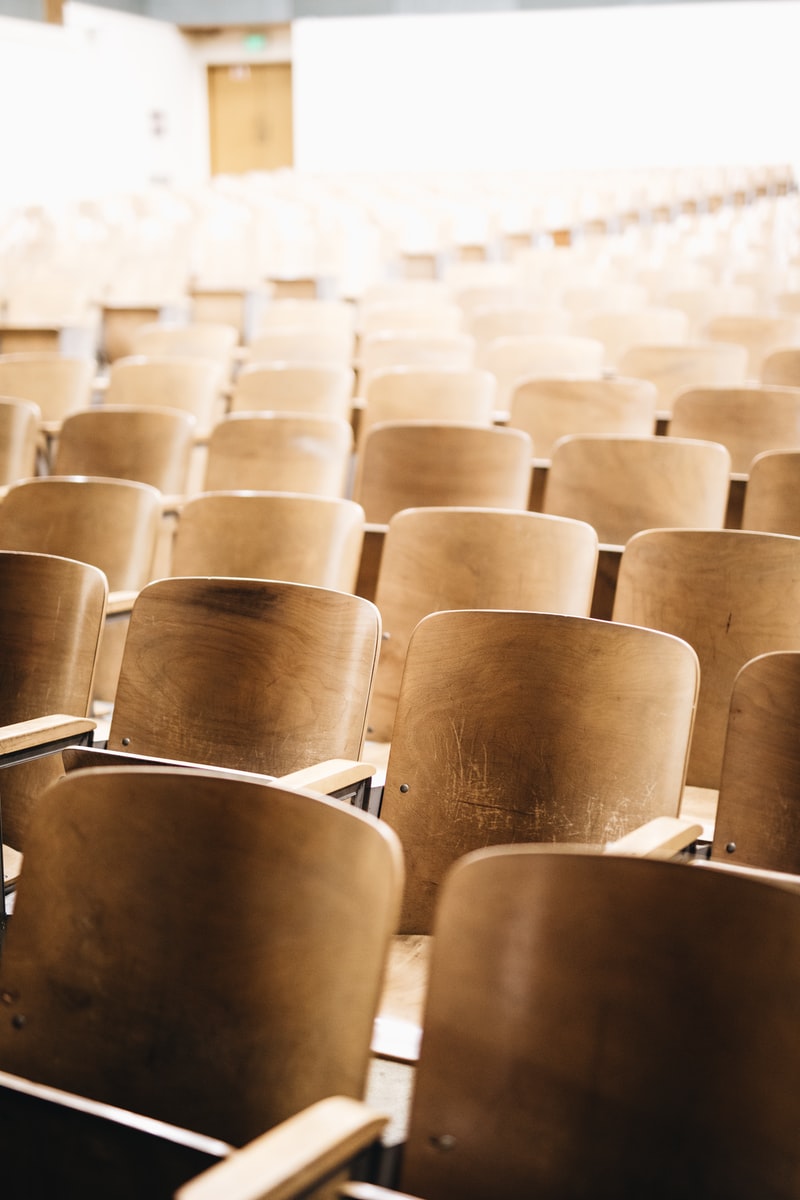 vacant brown wooden chair at stadium